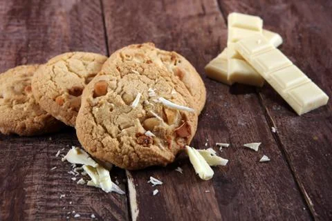 Stack of macadamia nut and white chocolate cookies on table with chocolate ch Stock Photos