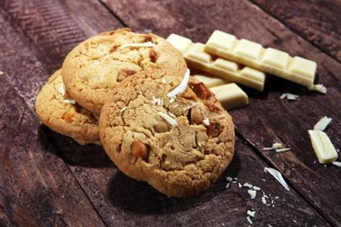Stack of macadamia nut and white chocolate cookies on table with chocolate ch Stock Photos