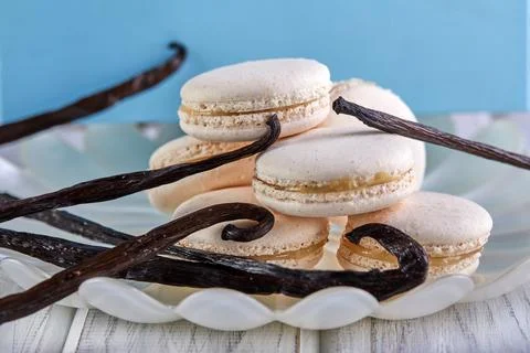 A stack of macarons and vanilla beans on a plate, a happy event Stock Photos