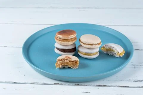 Stack of macarons filled with dulce de leche and chocolate ganache, next to t Stock Photos