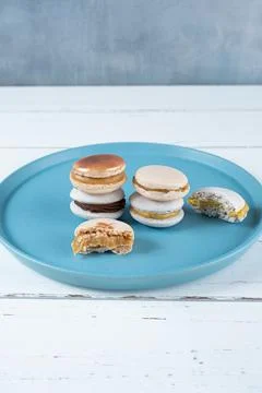 Stack of macarons filled with dulce de leche and chocolate ganache, next to t Stock Photos