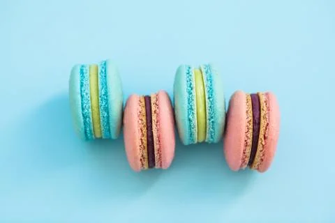 A stack of macaroons of various flavor biscuits on blue pastel background, to 写真素材