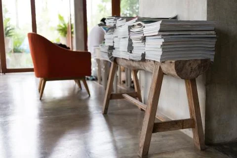 Stack of magazine books on wooden table shelf in living room Foto stock