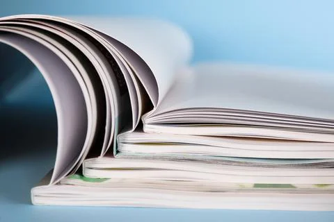 Stack of magazines on light blue background, closeup Stockfoto's