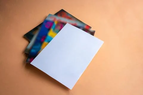 Stack of magazines with white paper cover on top. Stock Photos