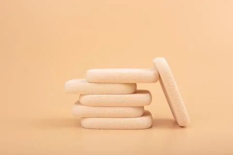 Stack of make up sponges for applying make up on beige background Stock Photos