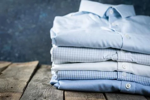 Stack of male folded shirts on rustic background Stock Photos