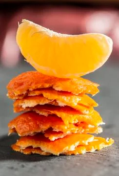 Stack of mandarin peel and a tangerine on top. Close-up shot of citrus fruits Stock Photos