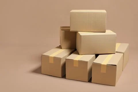 Stack of many cardboard boxes on light brown background, space for text Stock Photos