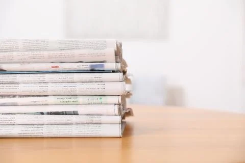 Stack of many newspapers in different languages on wooden table, space for te 写真素材