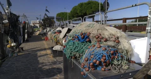Stack of many tangled fishing nets lying next to moored boats near road dayti Vídeo Stock 150205523