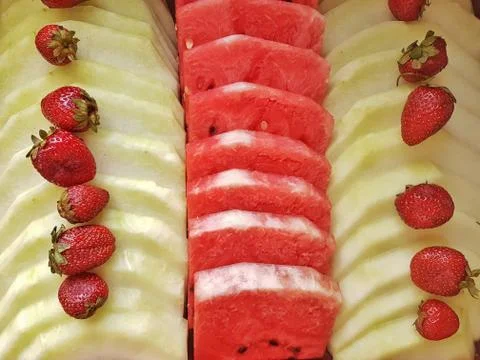 Stack of many watermelon slices, grapes and strawberries Stock Photos