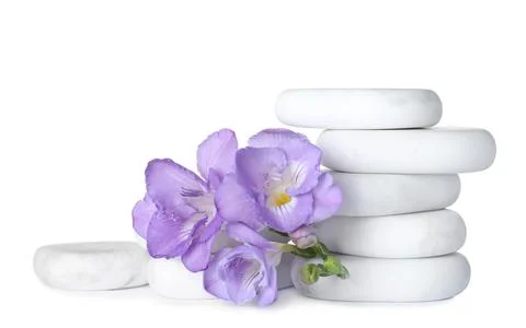 Stack of marble spa stones and fresh flowers isolated on white 스톡 사진