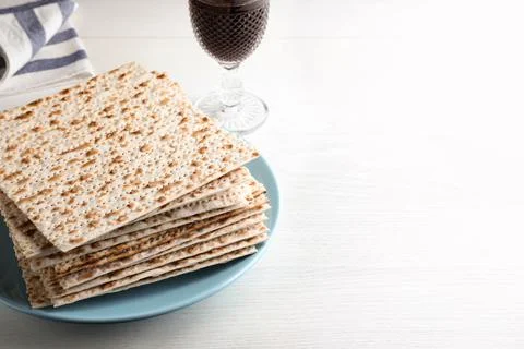 Stack of matzos and red wine on white table. Space for text 스톡 사진