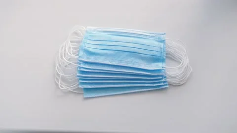 A stack of medical masks falls onto the table. Stock Footage 130438591