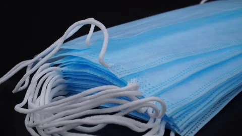 A stack of medical masks lies on a black background Stock Footage 128661778