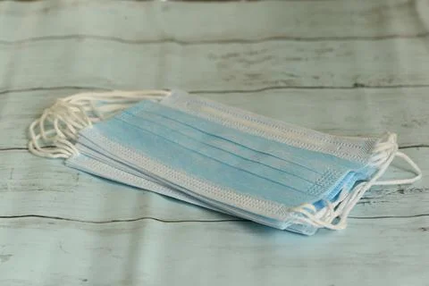 Stack of medical protective masks on blue background Stock Photos