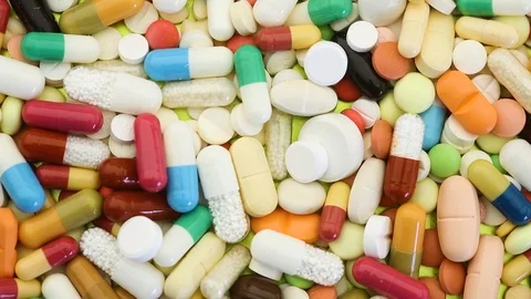 Stack of medication pills spinning through view Stock Footage 95476747