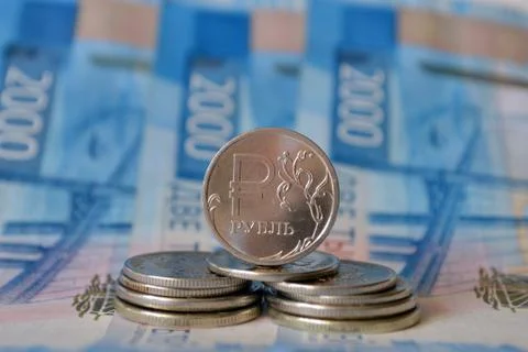A stack of metal coins on background of a 2000 rubles banknote Stock Photos