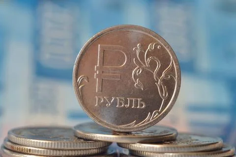 A stack of metal coins on a blue background Stock Photos