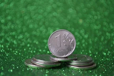 A stack of metal coins on a green background Stock Photos