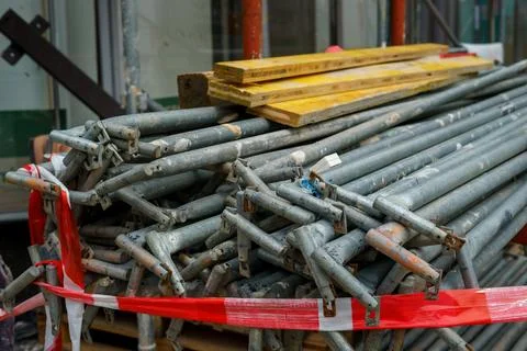 Stack of Metal Scaffolding Pipes Secured with Safety Tape Stock Photos