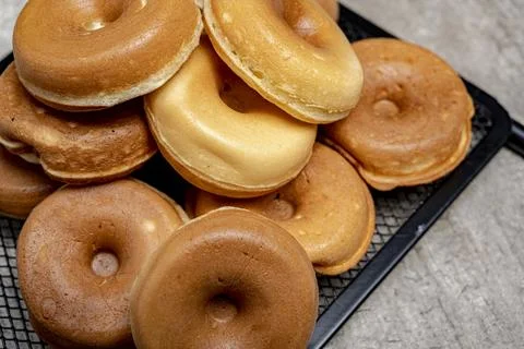 A stack of mini donuts on a black tray Stock Photos