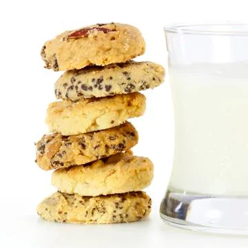 A stack of mixed fruit cookies and glass of milk Stock Photos