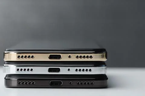 Stack of modern smartphones on white table, closeup. Space for text Stock Photos