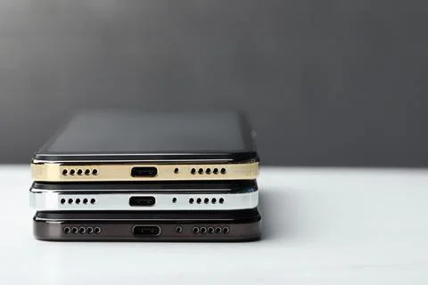 Stack of modern smartphones on white table, closeup. Space for text Foto stock