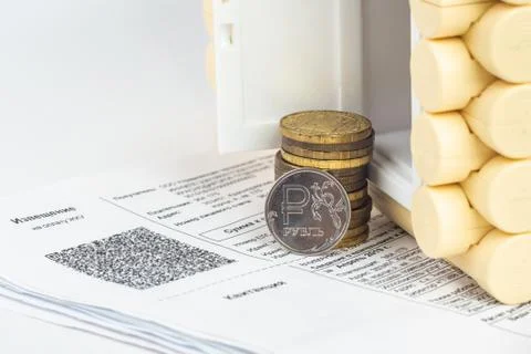 A stack of money and one ruble coin in the accounts for the apartment, in fro Fotos Stock