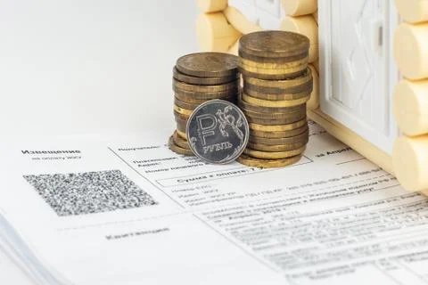 A stack of money and one ruble coin in the bills for an apartment Fotos Stock