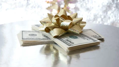 Stack of money with bow rotation on silver xmas background, merry christmas,  Stock Footage 143590673