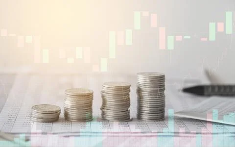 Stack of money coin on accounting sheet with trading graph Stock Photos
