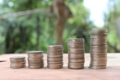 Stack of money coins arranged as a graph on wooden table Stock Photos