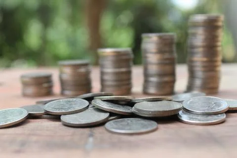 Stack of money coins arranged as a graph on wooden table Stock Photos