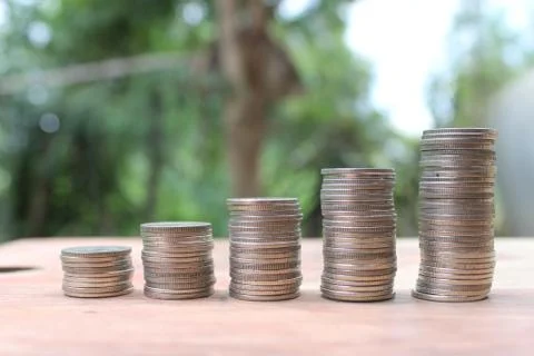 Stack of money coins arranged as a graph on wooden table Stock Photos