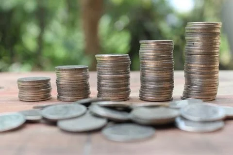 Stack of money coins arranged as a graph on wooden table Stock Photos