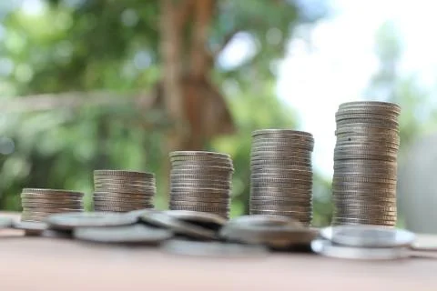 Stack of money coins arranged as a graph on wooden table Stock Photos