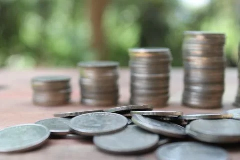 Stack of money coins arranged as a graph on wooden table Stock Photos
