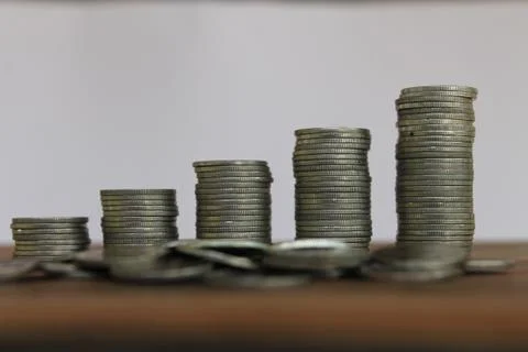 Stack of money coins arranged as a graph on wooden table Stock Photos