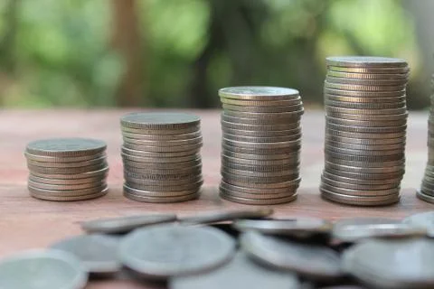 Stack of money coins arranged as a graph on wooden table Stock Photos