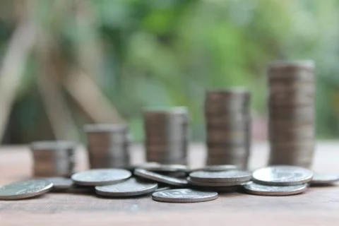 Stack of money coins arranged as a graph on wooden table Stock Photos
