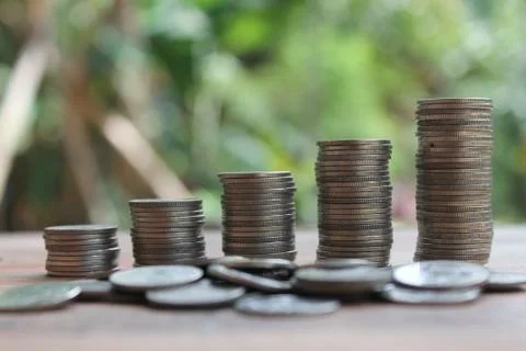 Stack of money coins arranged as a graph on wooden table Stock Photos