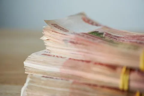 Stack of money on wooden table, shallow depth of field, selective focus. Stock Photos
