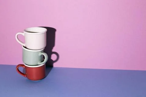 Stack of mug cup on blue table. purple wall background. copy space Stack o... Stock Photos