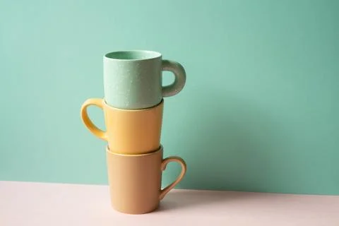 Stack of mug cup on pink table. mint green wall background Stock Photos