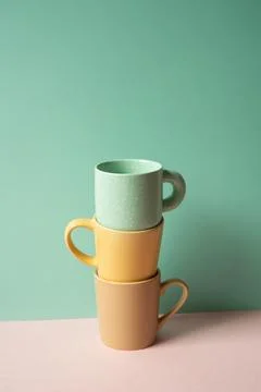 Stack of mug cup on pink table. mint green wall background Stock Photos