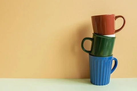 Stack of mug cups on table. orange background Stack of mug cups on table. ... Stock Photos
