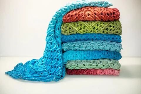 A stack of multi-colored knitted things on a white background Stock Photos